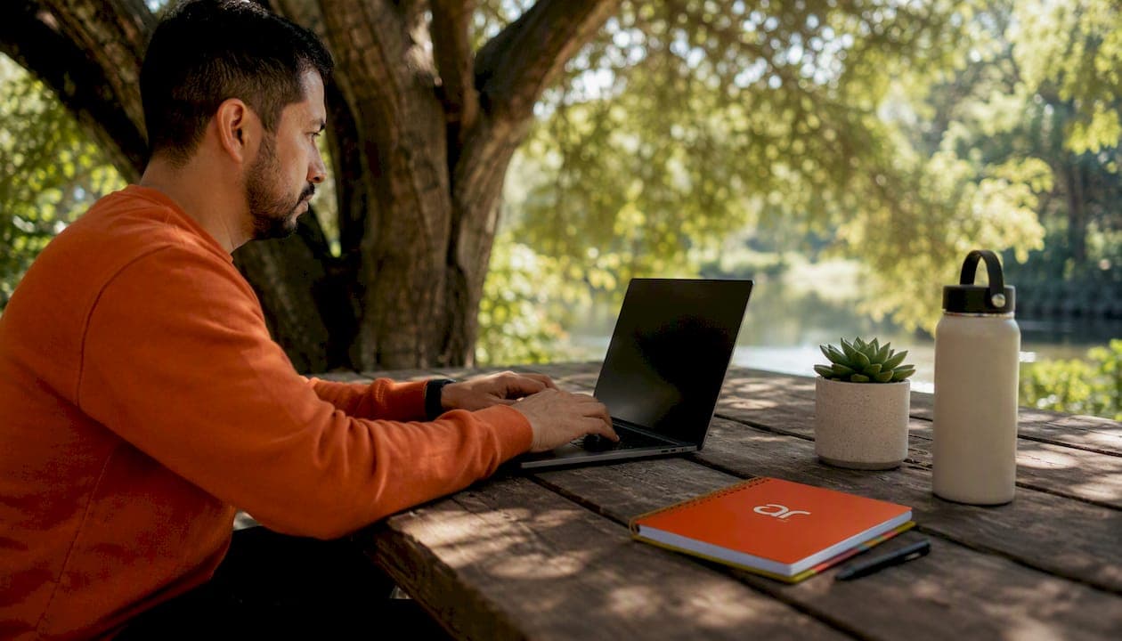 Hands typing on laptop in co-working space