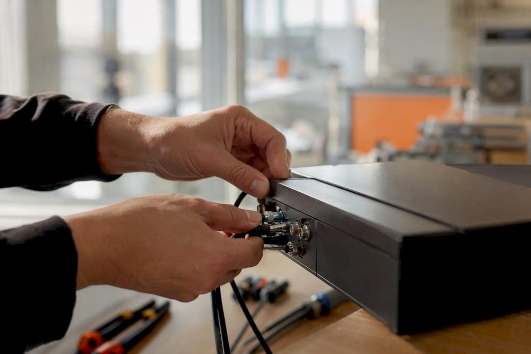Hands connecting sensor cables to machinery