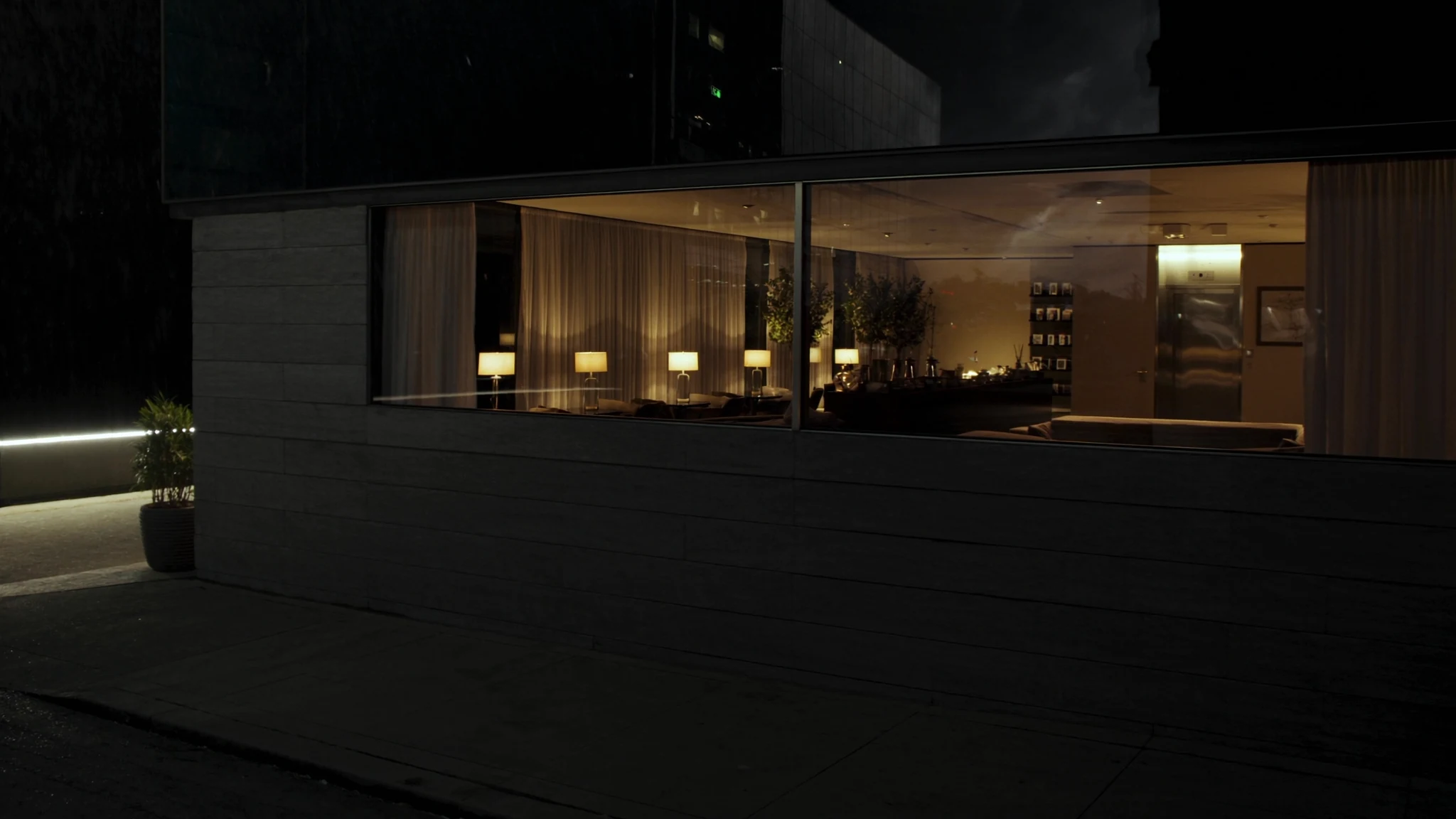 Night view into an agri-food headquarters lobby, a corridor of warm light toward the rooms where decisions are made