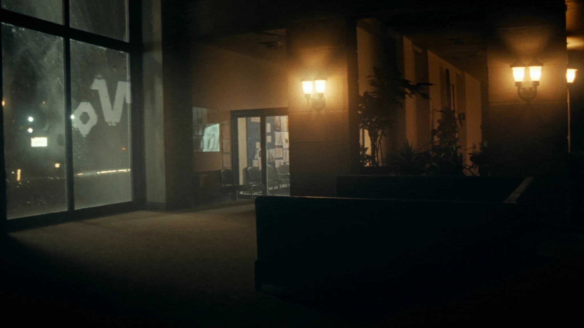 Night view into an automotive headquarters lobby, a corridor of warm light toward the rooms where decisions are made