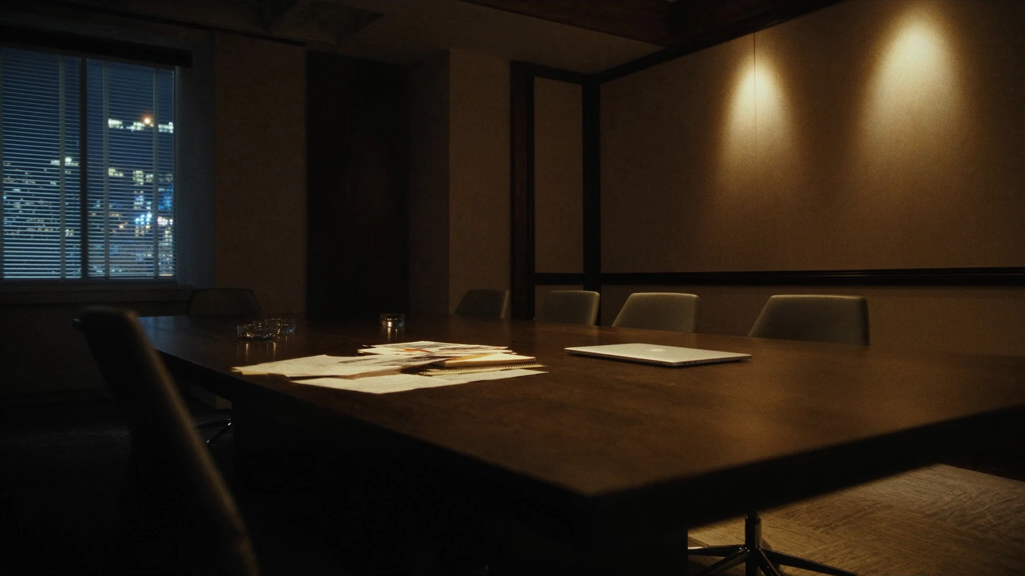 After-hours conference table in an automotive office, laptop and espresso waiting for a decision that has no owner