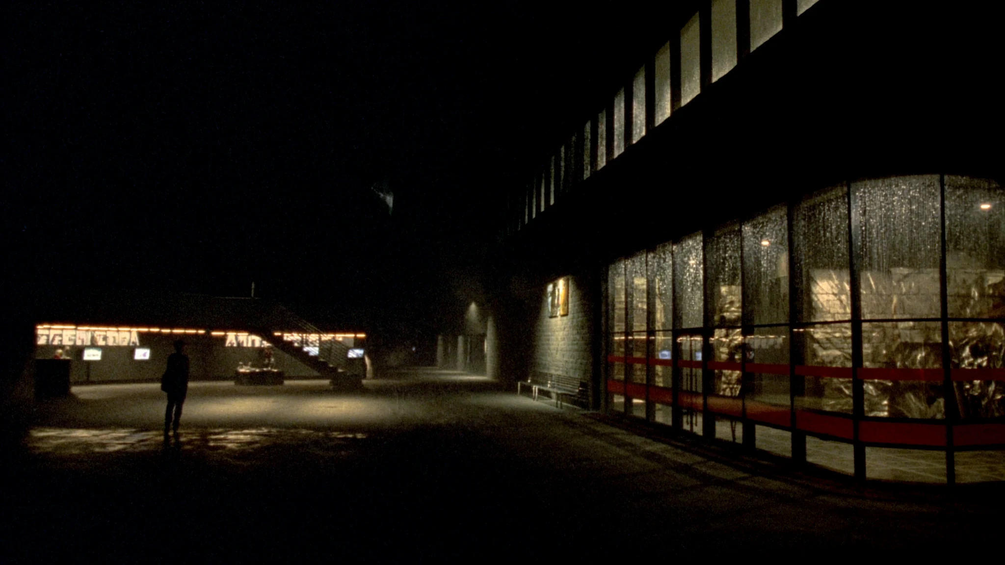 Night view into a plant lobby, a corridor of warm light toward the rooms where decisions are made