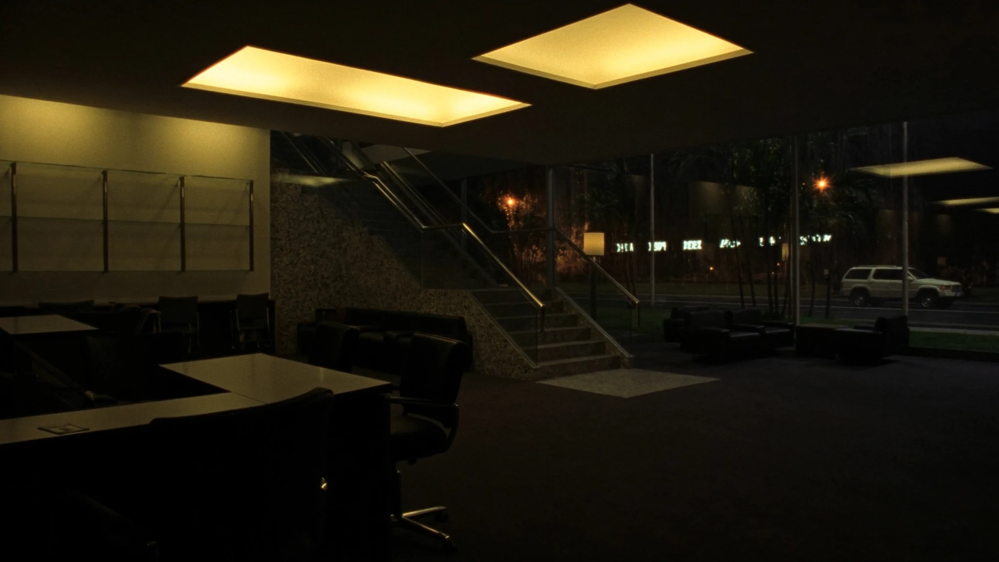 Night view into a bank lobby, a corridor of warm light toward the rooms where decisions are made