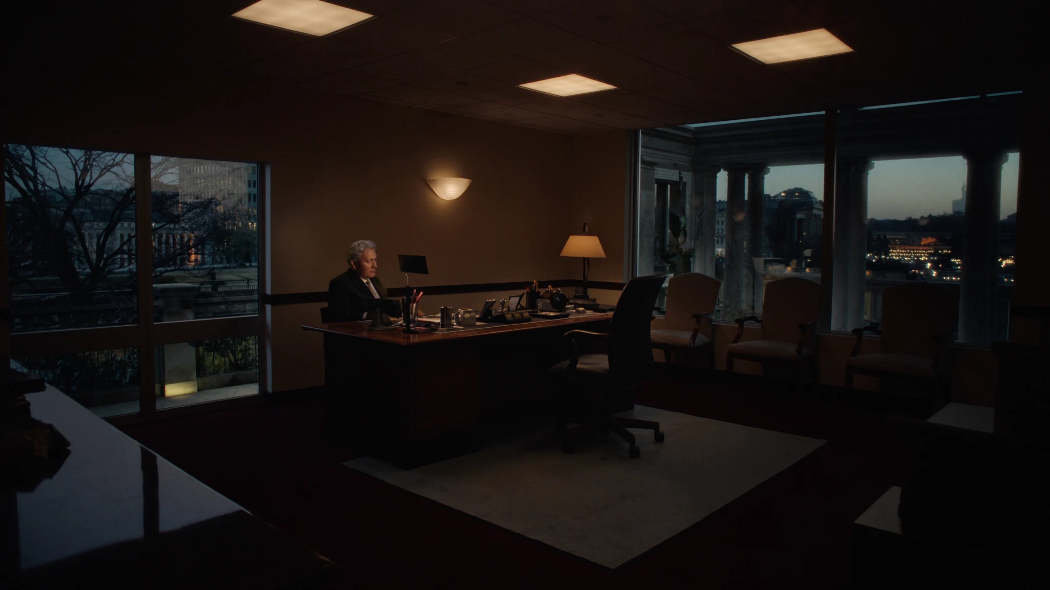 Night executive desk in a civic operations wing, the office after the meeting