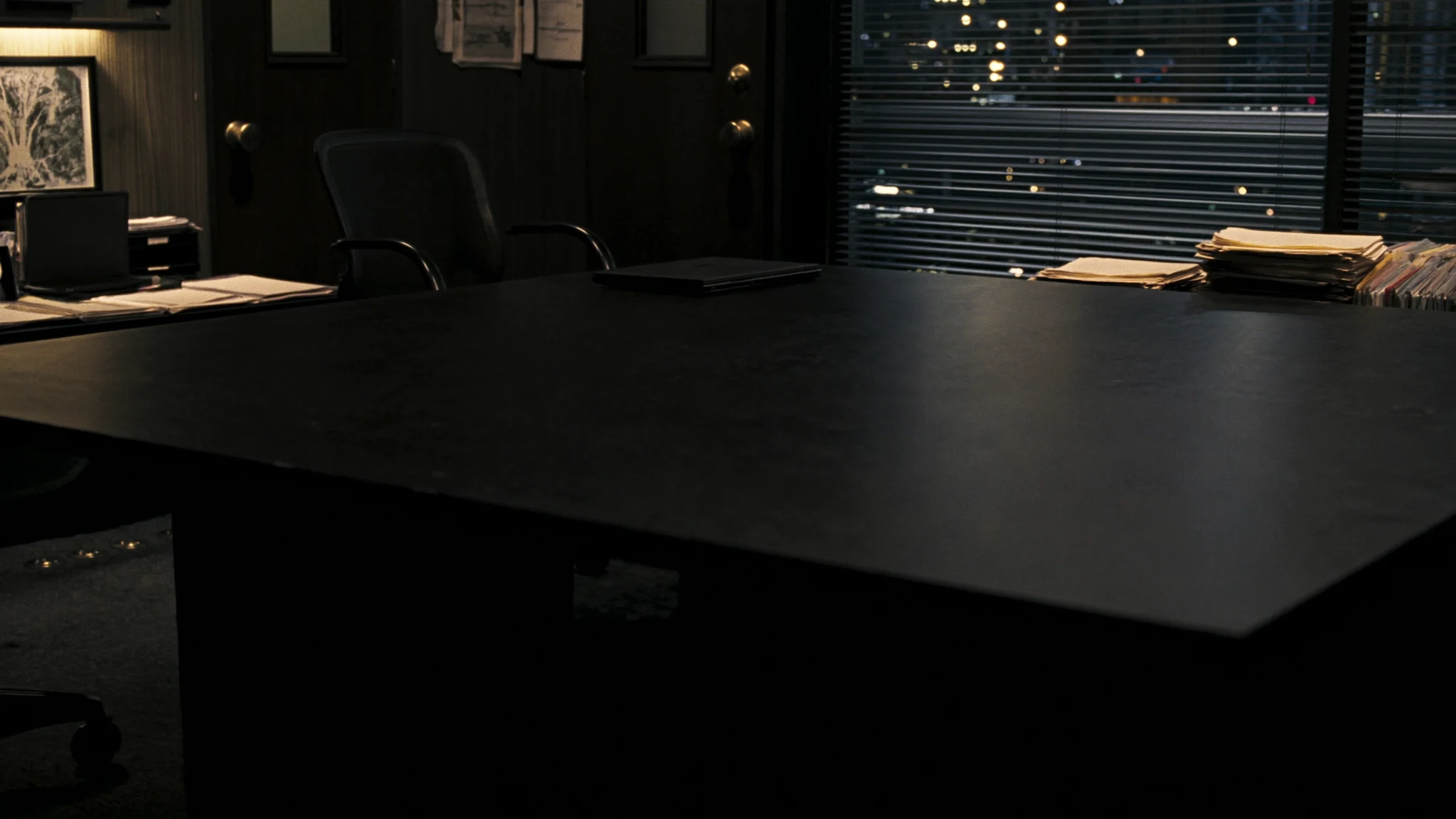 After-hours conference table in a civic office, laptop and coffee waiting for a decision that has no owner