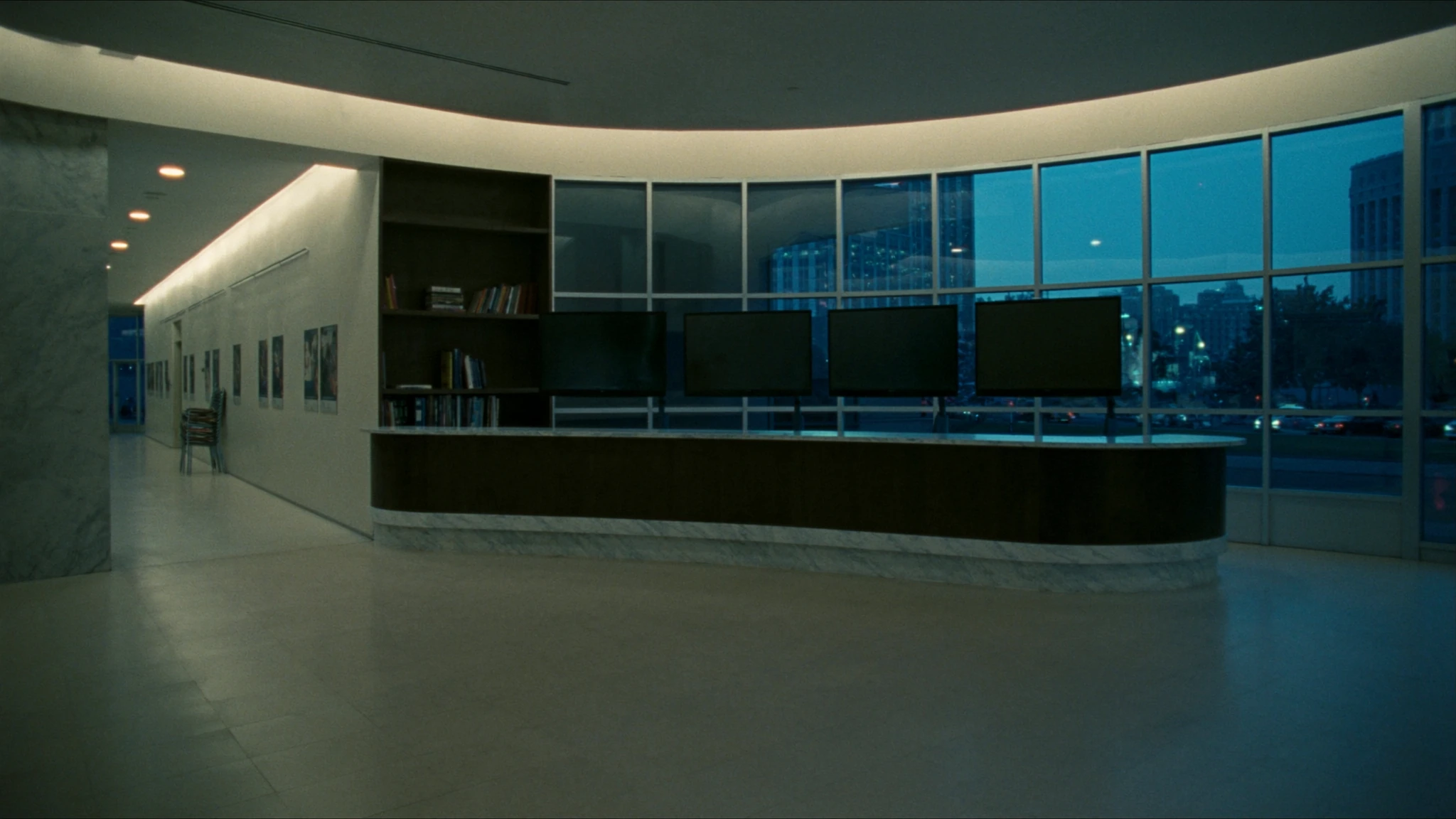 After-hours hospital corridor, a single chair outside the rooms where the AI function is decided