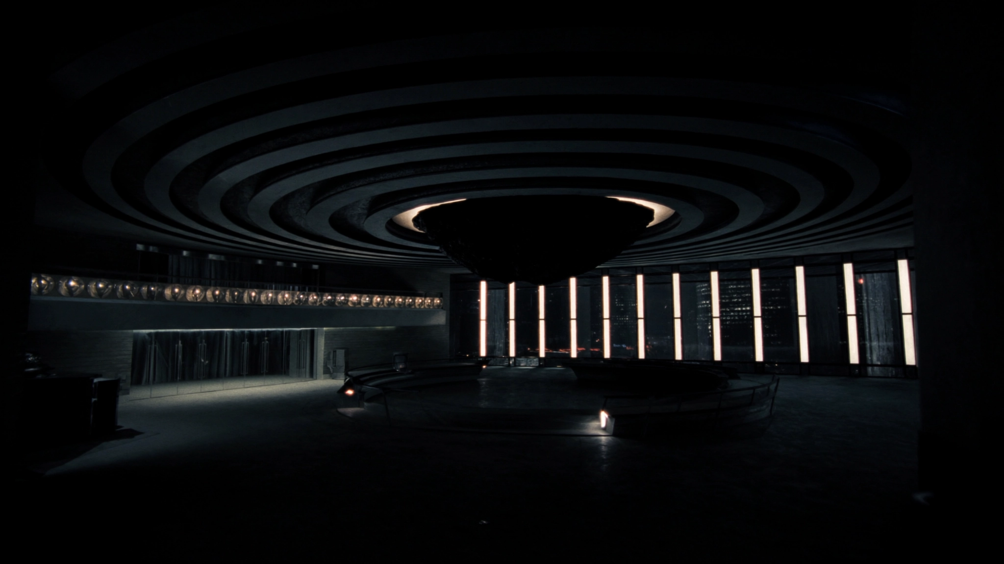 Dark hospital lobby at night, a corridor of light toward the rooms where decisions are made