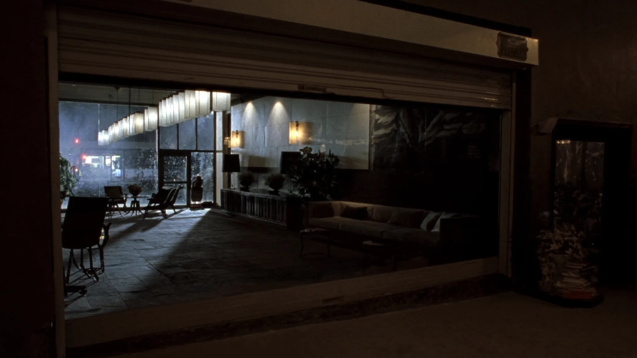 Night view into a hospitality headquarters corridor, warm light toward the rooms where decisions are made