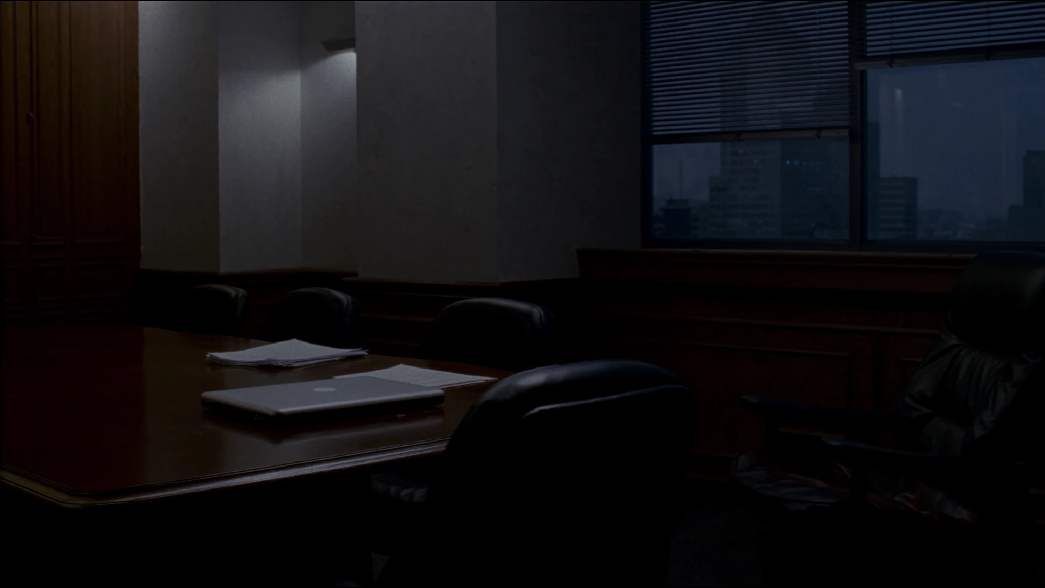 After-hours conference table in a law firm, laptop and espresso waiting for a decision that has no owner