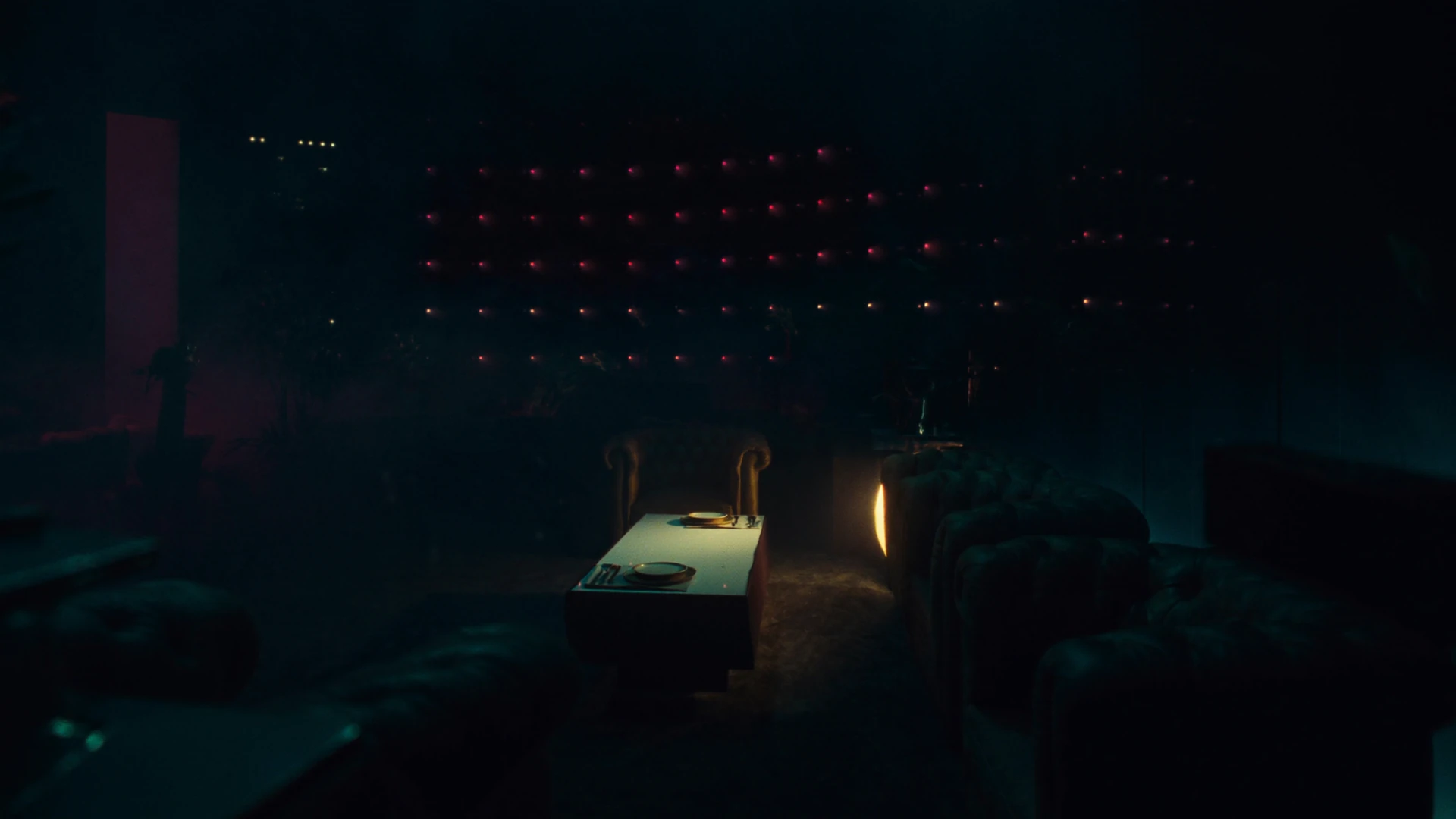 Empty armchair facing a lit table, a wall of red indicators behind it