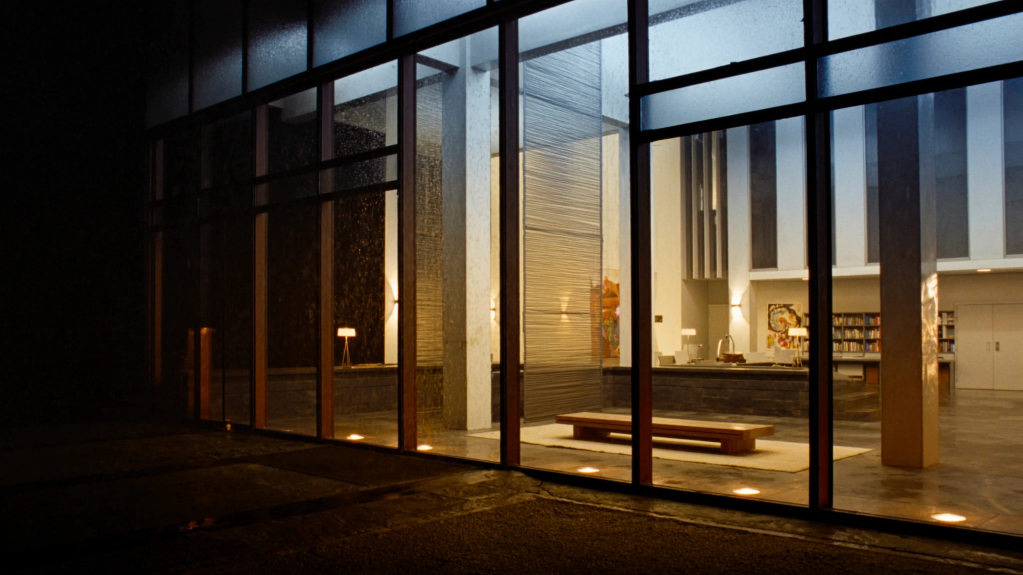 Night view into a developer lobby, a corridor of warm light toward the rooms where decisions are made