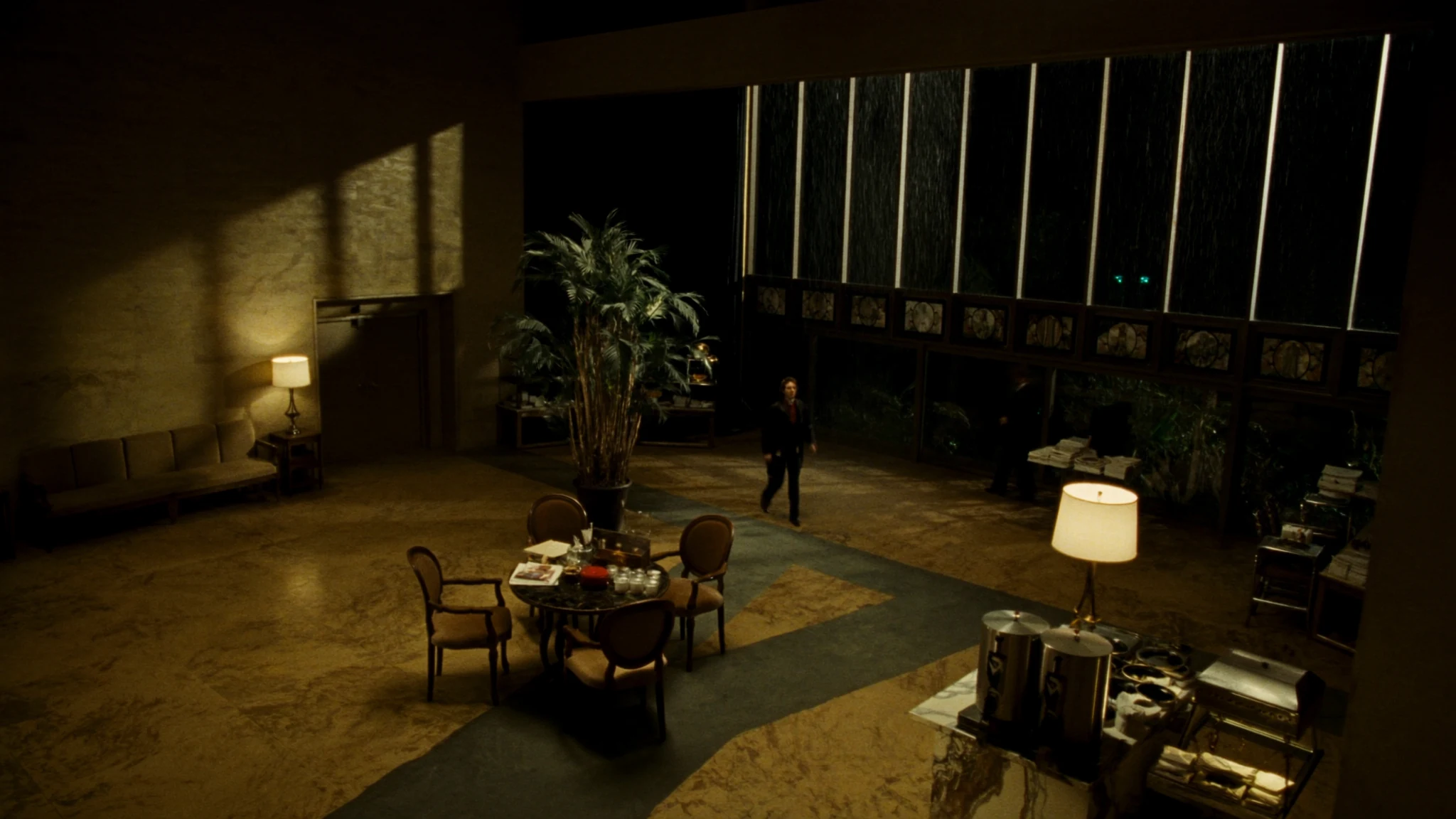 Night view into a retail headquarters lobby, a corridor of warm light toward the rooms where decisions are made